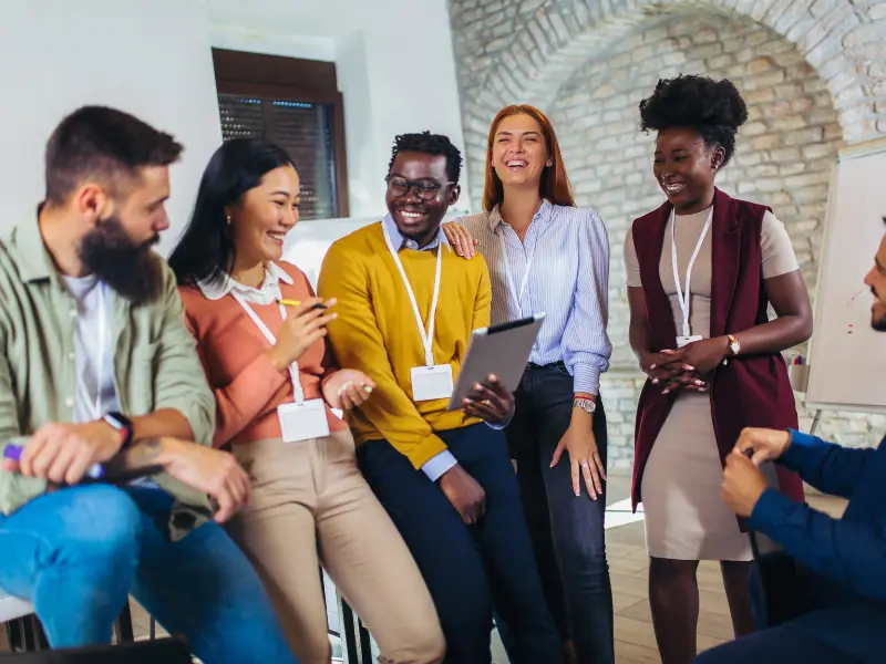 Mitarbeiterzufriedenheit in hybriden Arbeitsmodellen. Multikulturelles Team von glücklichen Mitarbeitern im Büro.