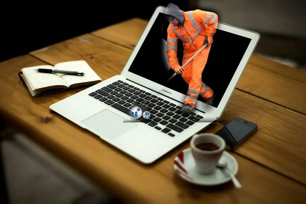 Illustration eines digitalen Arbeitsplatzes mit Bauarbeiter auf Laptop – symbolisiert Datenpflege, Sicherheit und Datenschutz im Homeoffice