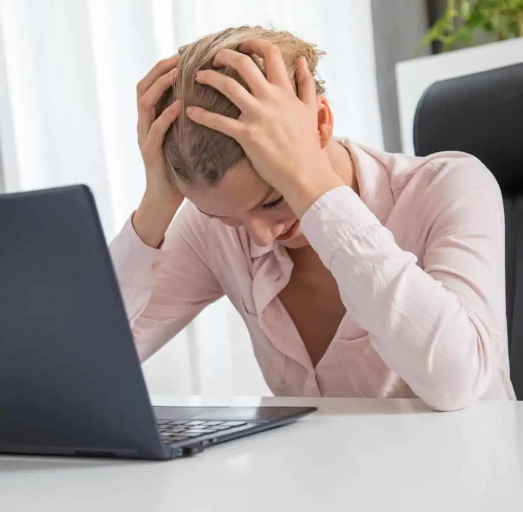 Frau am Laptop mit Stresssymptomen – psychische Belastung im Homeoffice